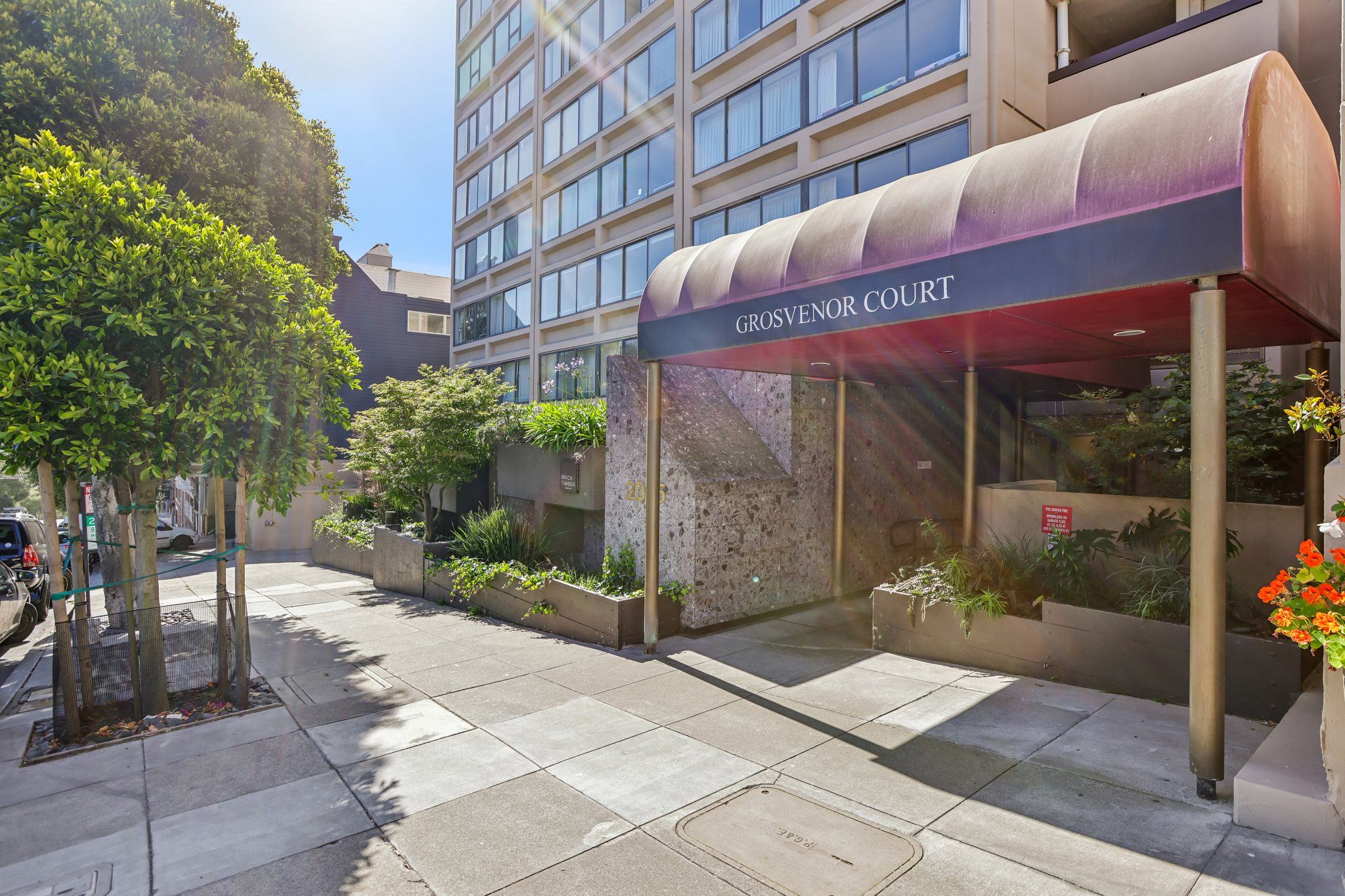The entrance to Grosvenor Court is framed by a row of trees.